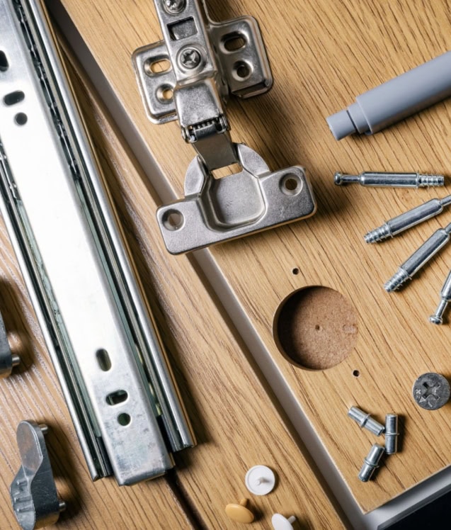 Close-up of fasteners and hardware parts on a wooden surface.